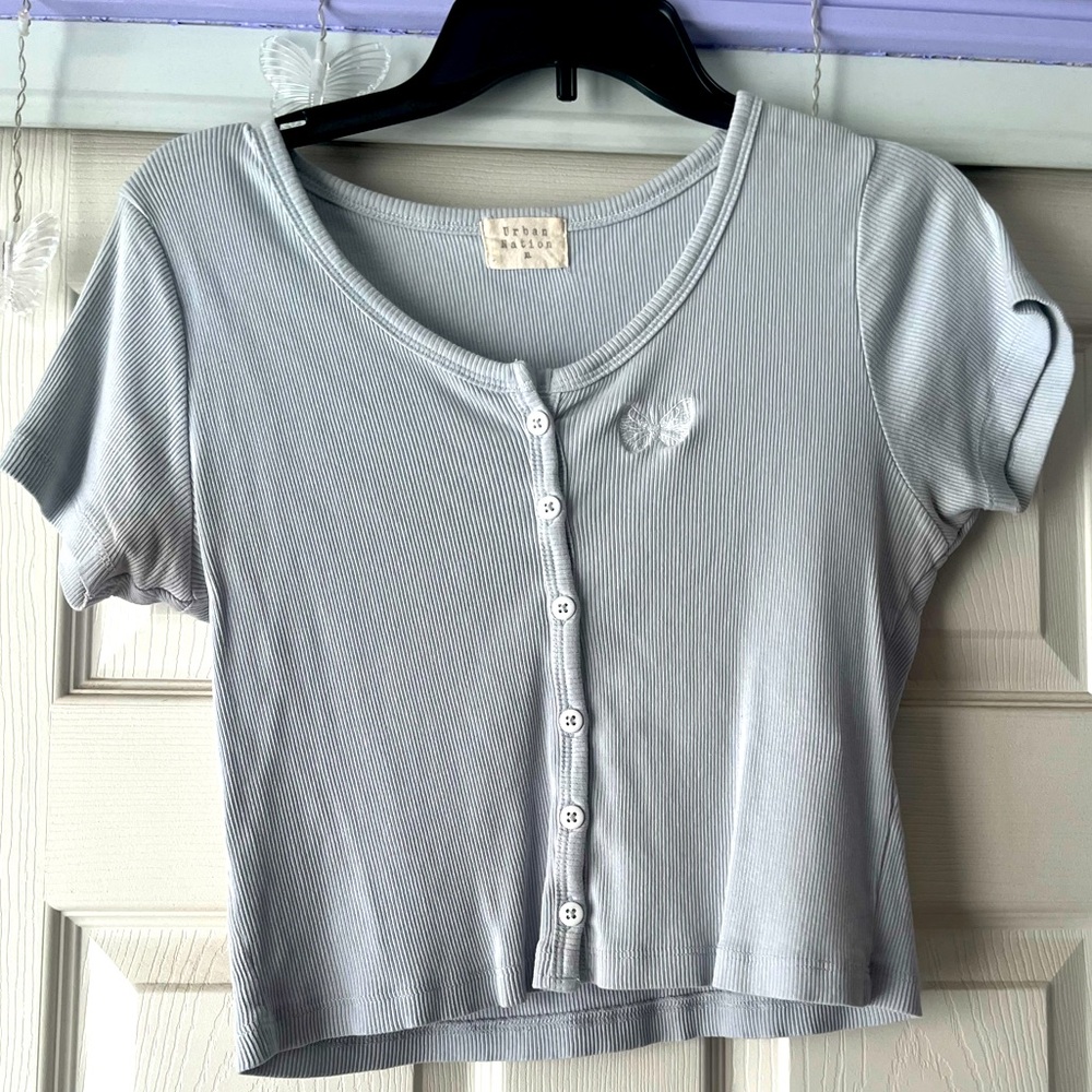 Light blue slightly cropped shirt, fits tight but loose.